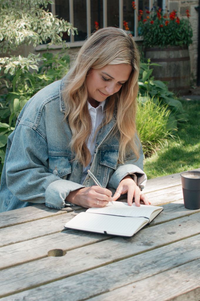 Woman sitting at a picnic bench writing in a notebook. Text over the image says 'Clients I have worked with.'